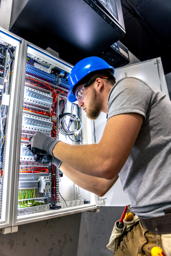 male electrician uniform working switchboard electricity